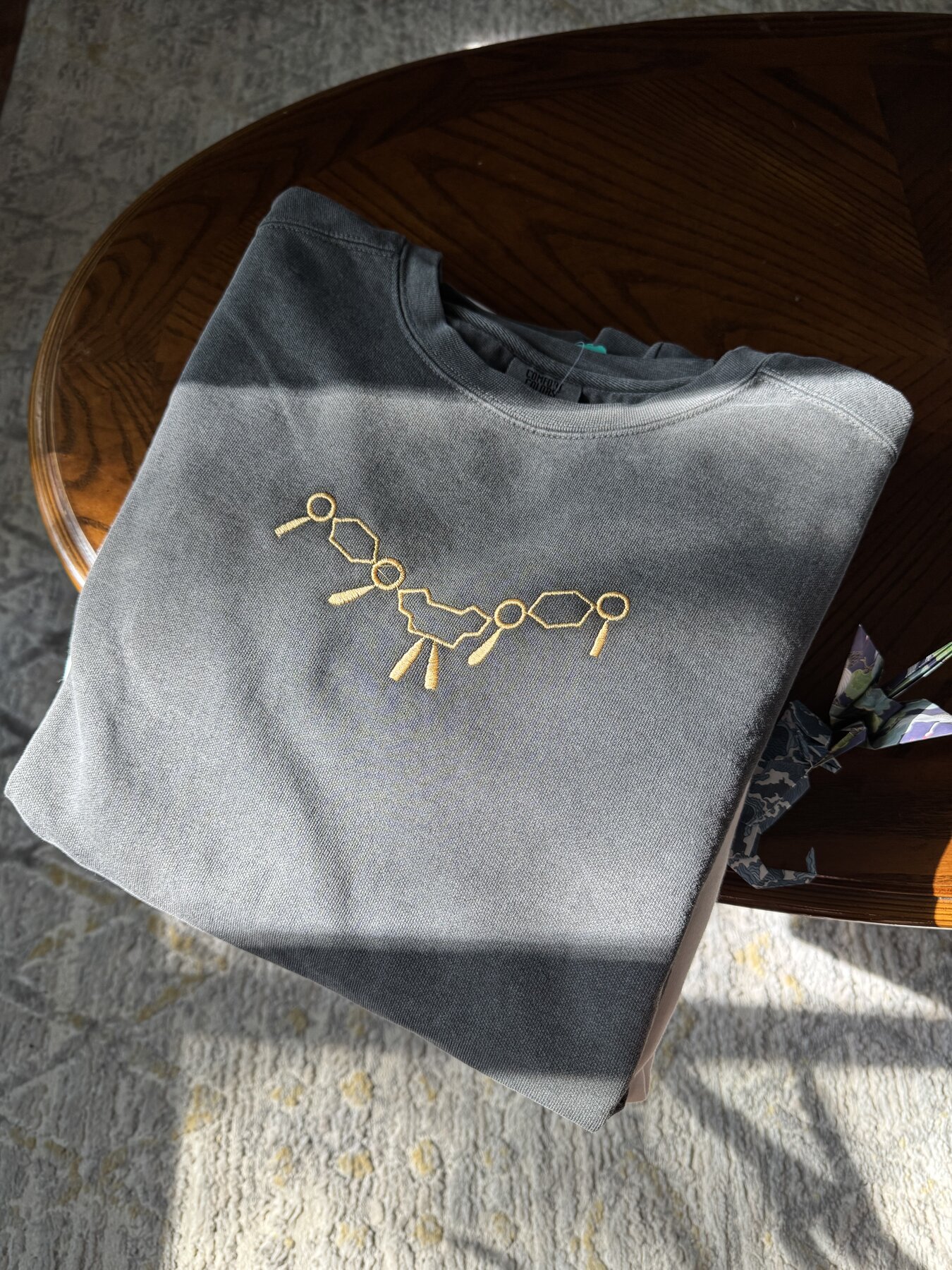 Sword and blue rose crest embroidered on a navy Champion crewneck